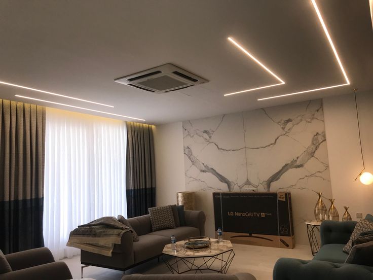 a living room filled with furniture and a flat screen tv mounted to the wall next to a window