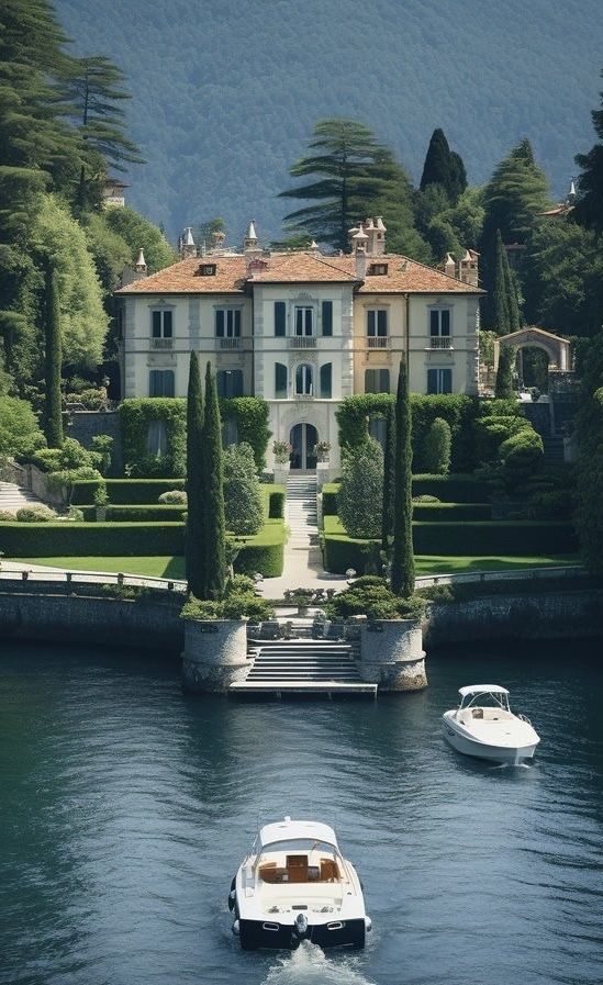 two boats are in the water near a large house with trees and bushes around it