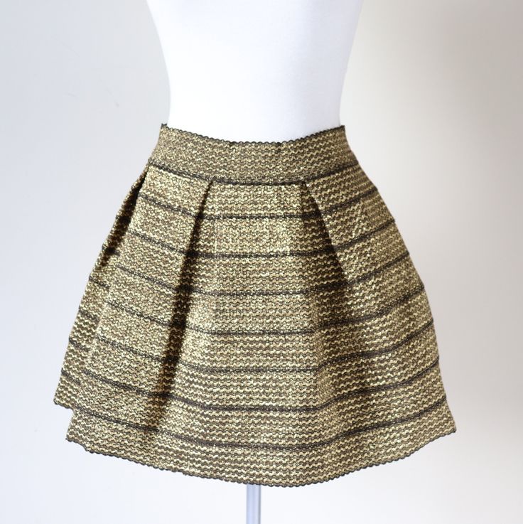 Fabulous Sculptural Shape! Stiffened gold stretchy polyester skirt by Ginger G with box pleats for a full shape. The skirt sits on the mid waist and is stretchy in the waistband and throughout. Made in China The size label is L. In my opinion the fit is a Large / UK 14 The garment is a mid weight and is unlined. Excellent Condition. Bright Clean Fresh Colour. No Notable Flaws. FLAT Measurements (Unstretched) (1 cm = 0.39 inches) Shoulder: 42 cm Sleeve: 55.5 cm Bust: 44 cm Waist: 37 cm Hip: 55 cm Chic Gold Mini Skirt For Party, Party Flared Pleated Skirt With Elastic Waistband, Fitted Gold Skirt For Spring, Chic Pleated Skirt With Elastic Waistband For Parties, Chic Gold Lined Skirt Bottoms, Chic Gold Bottoms With Lined Skirt, Chic Gold Mini Length Bottoms, Chic Gold Skirt, Chic Gold Mini Skirt