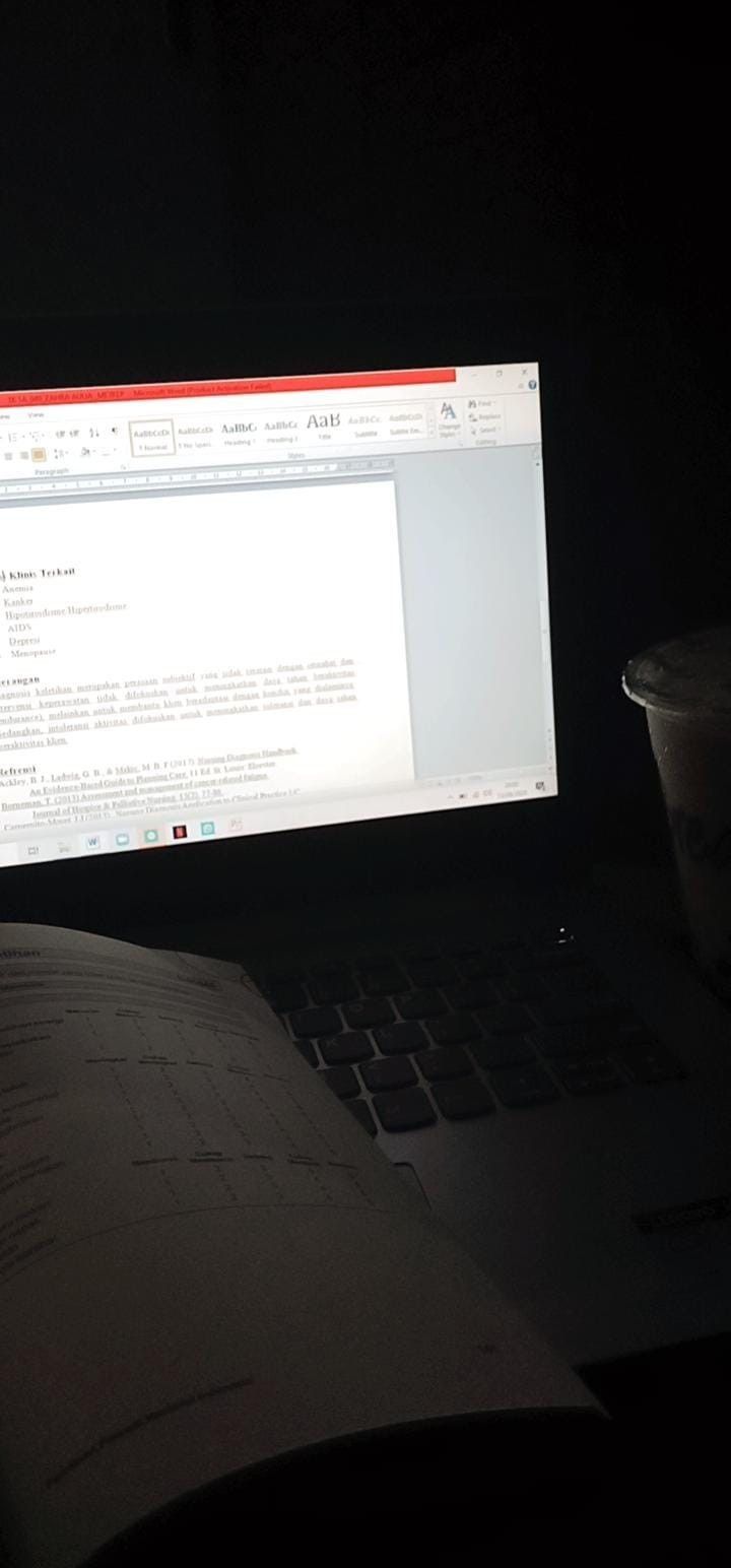 a laptop computer sitting on top of a desk next to a coffee cup and book