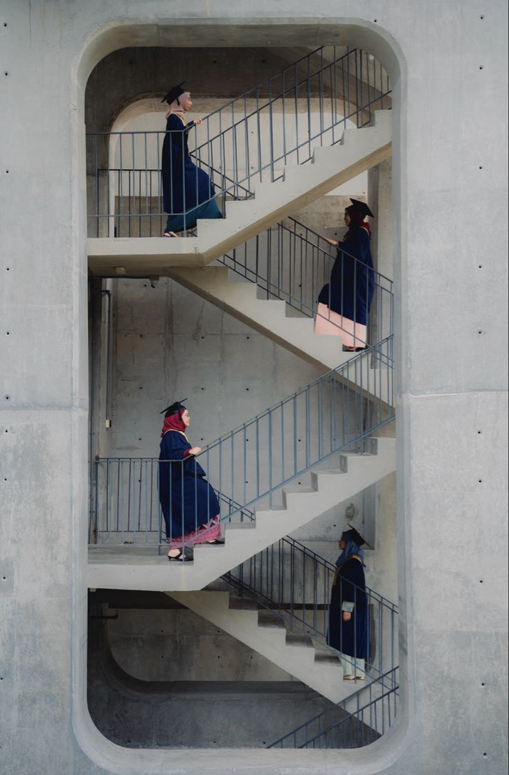 three people are walking up and down the stairs