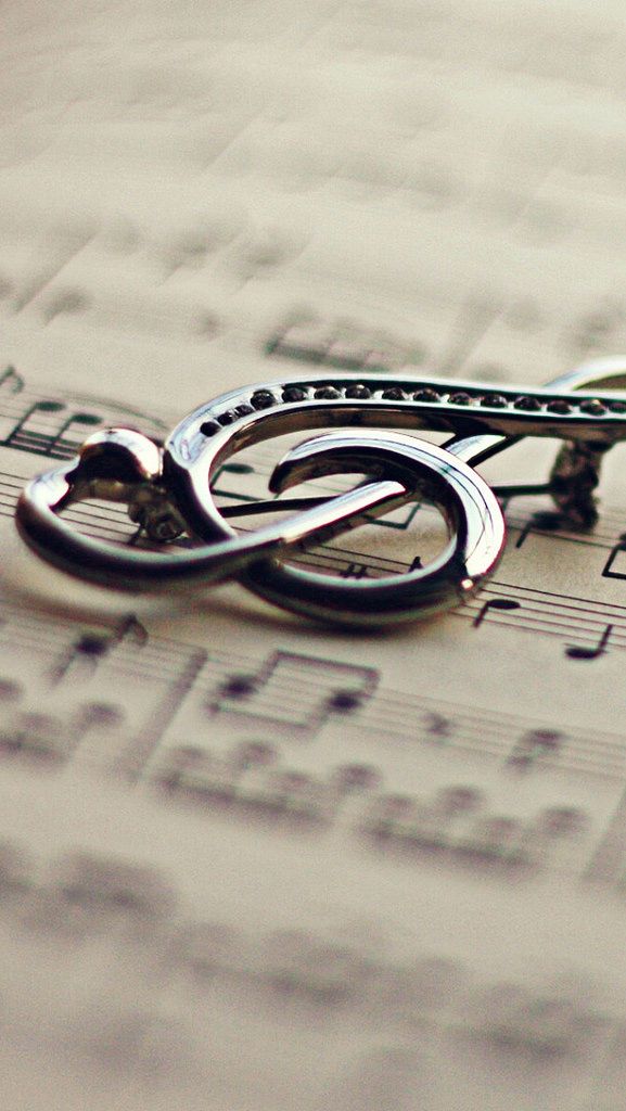 a pair of scissors sitting on top of sheet music