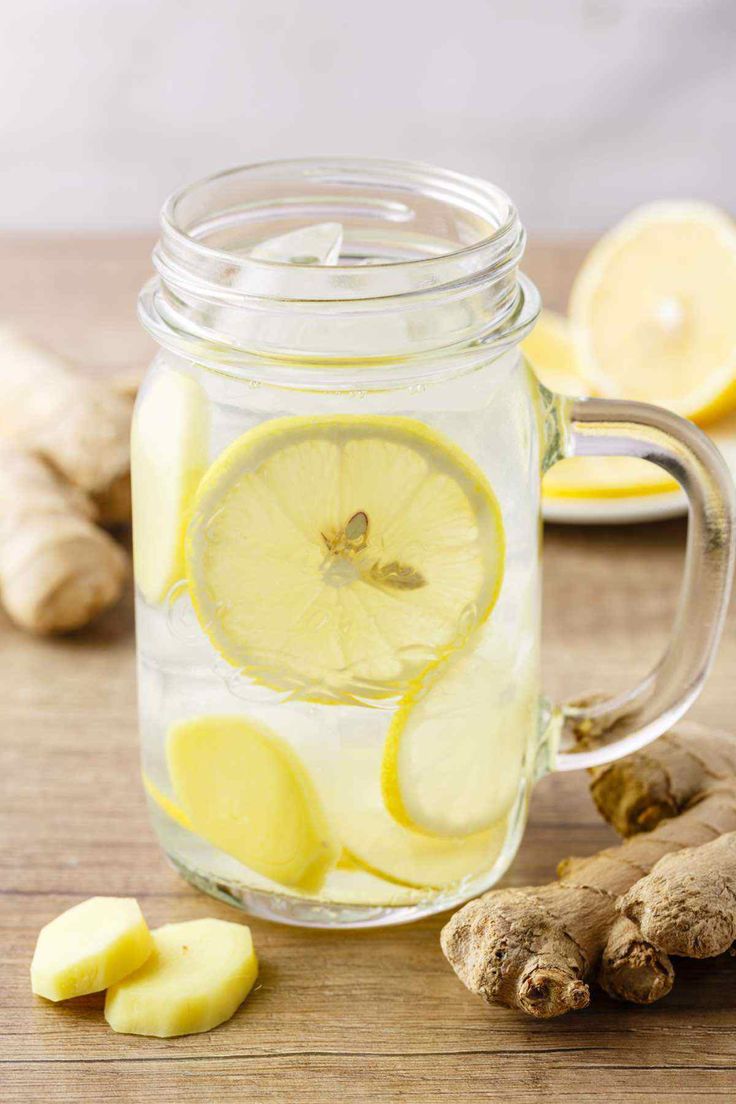 a mason jar filled with lemon slices and ginger