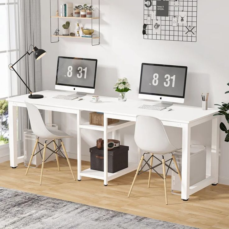 two computer monitors sitting on top of a white desk