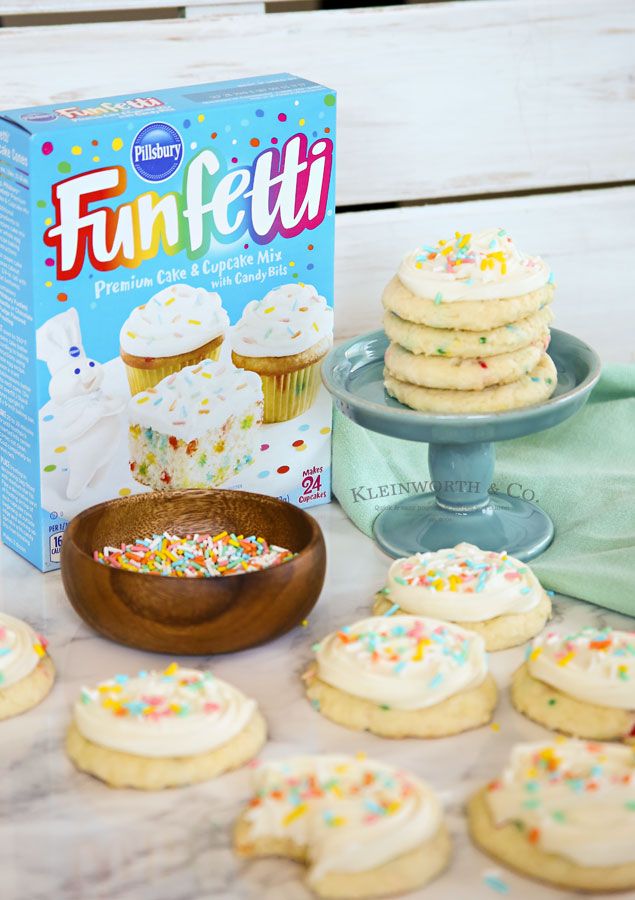 a box of funfetti cookies next to some cupcakes on a table