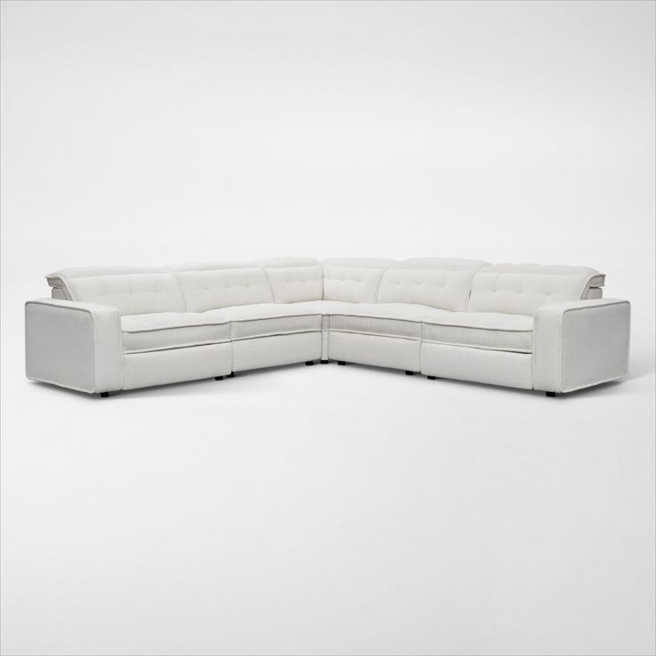 a white sectional couch sitting on top of a white floor