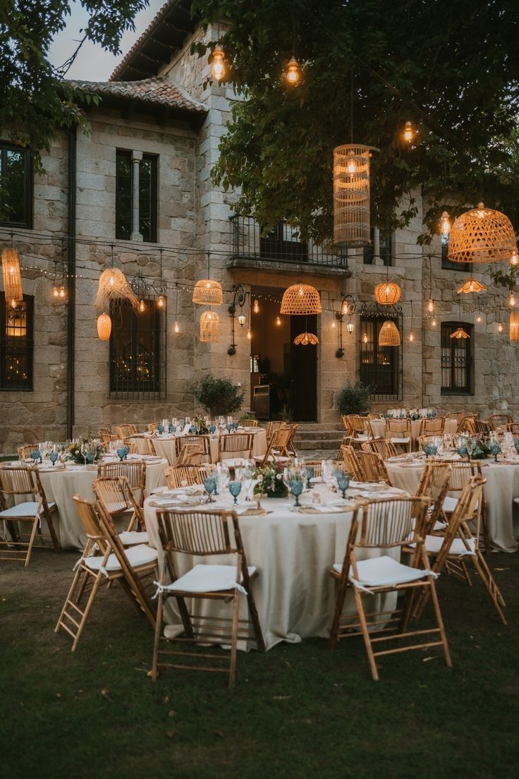 an outdoor venue with tables and chairs set up in front of the building at night