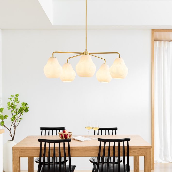 a dining room table with four chairs and a light fixture hanging over it's head