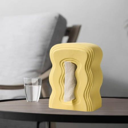 a yellow object sitting on top of a wooden table next to a glass of water