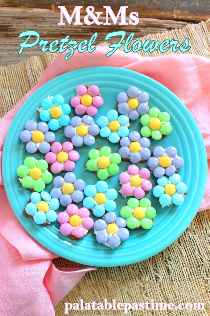 a blue plate topped with colorful cookies on top of a pink napkin and wooden table