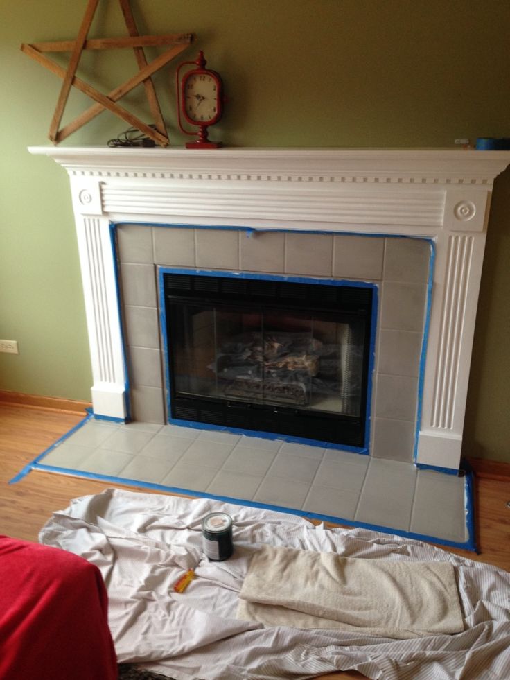 the fireplace is being painted white with blue tape