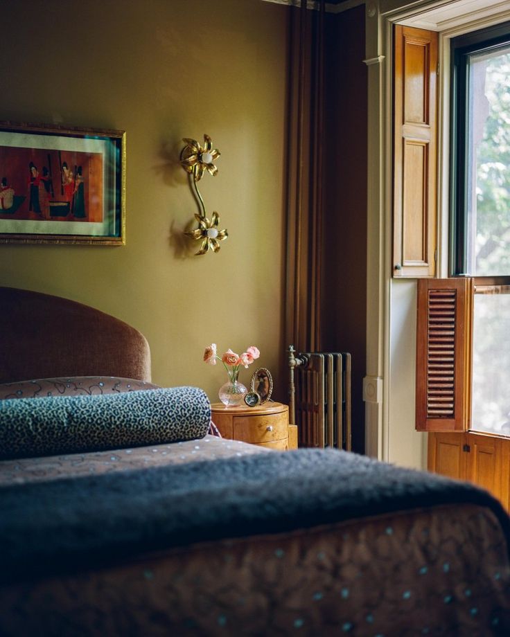 a bed sitting next to a window in a bedroom