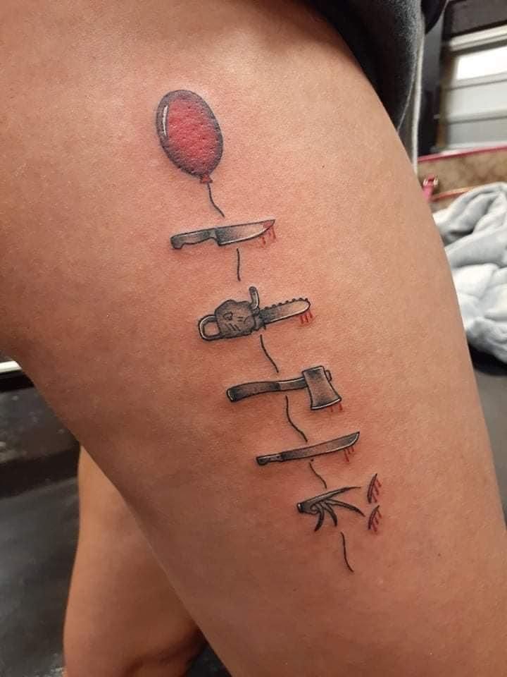 a woman with a tattoo on her thigh that has scissors and a balloon attached to it