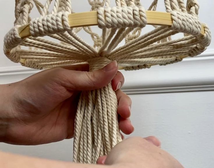 a hand holding a piece of rope that has been knotted together