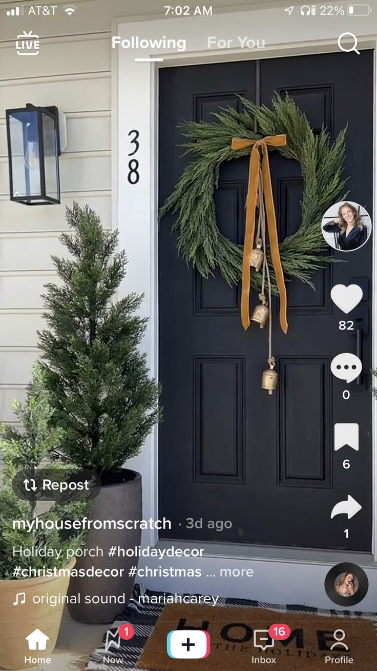 the front door is decorated for christmas with wreaths, bells and decorations on it