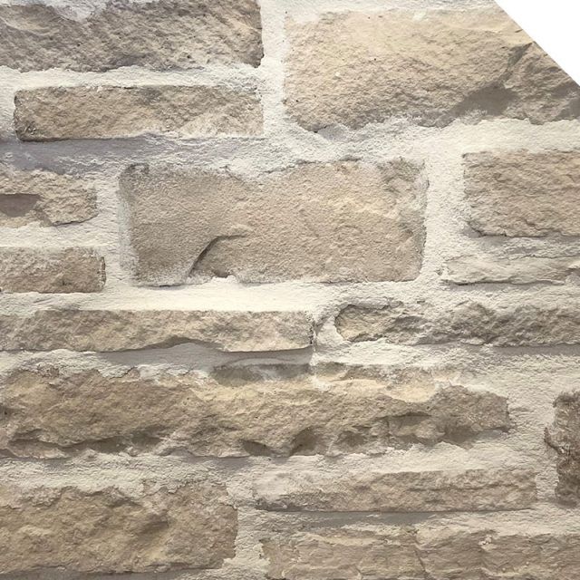 a brick wall that is made out of various types of stone and has no mortar or mortar