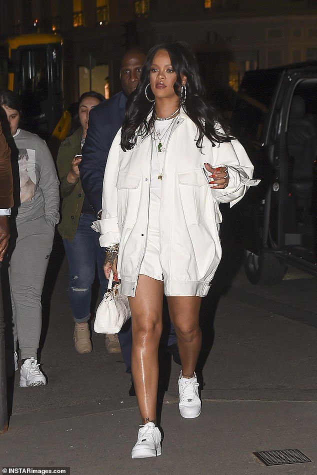 a woman in white is walking down the street