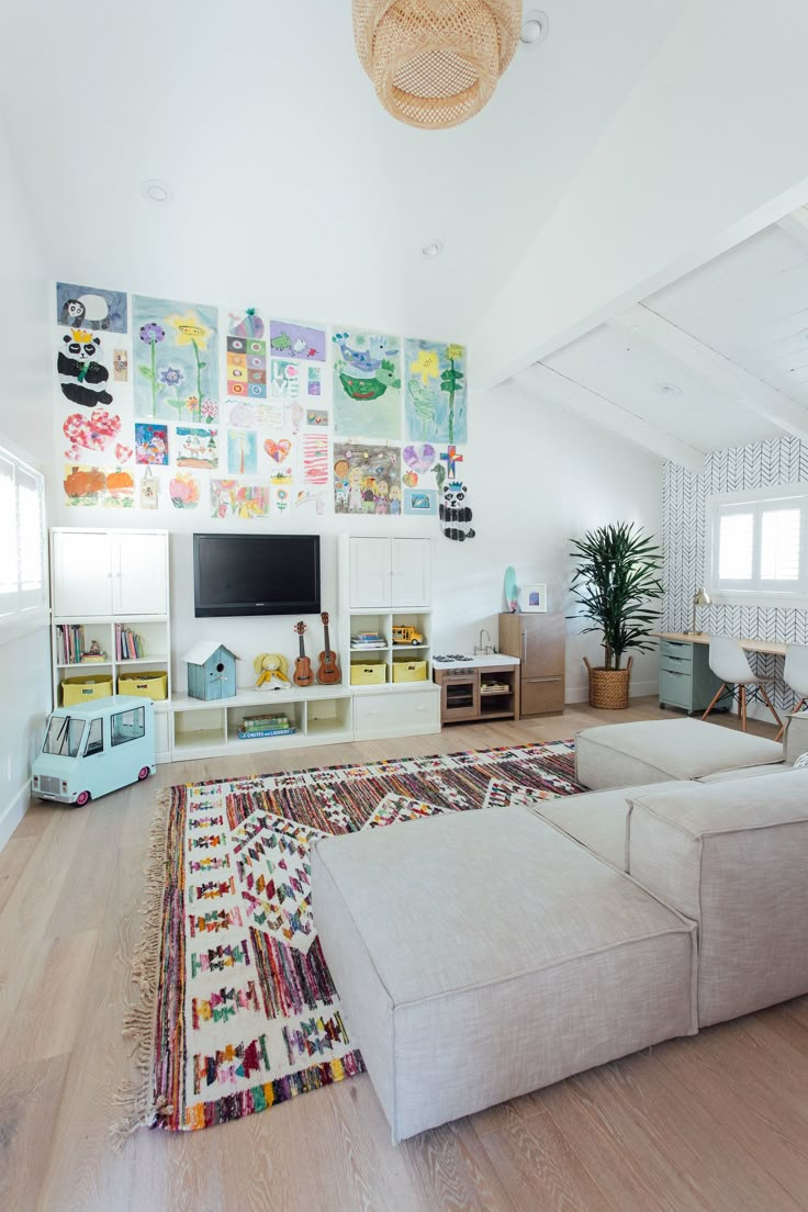 a living room with white furniture and lots of pictures on the wall