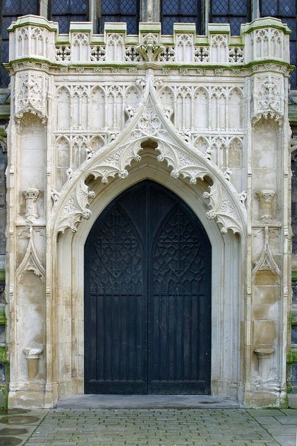 an old building with a large black door and ornate carvings on the front entrance to it