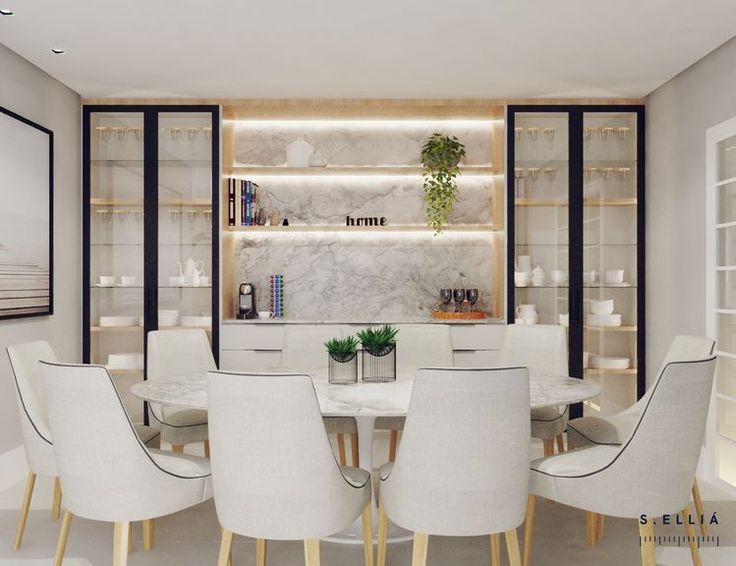 a dining room with white chairs and a marble table surrounded by built - in shelves