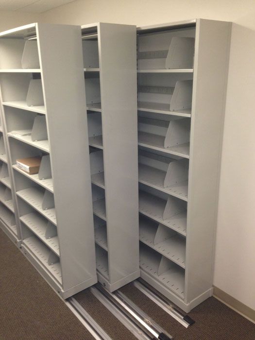 two tall white bookcases in an empty room with no one on the floor