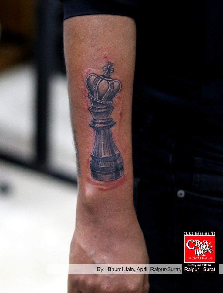 a man's arm with a tattoo on it that has a chess piece on it