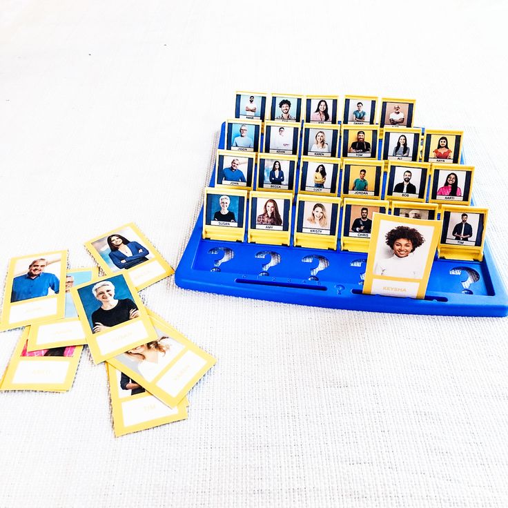 a blue tray filled with pictures next to a pile of cards on top of a white table