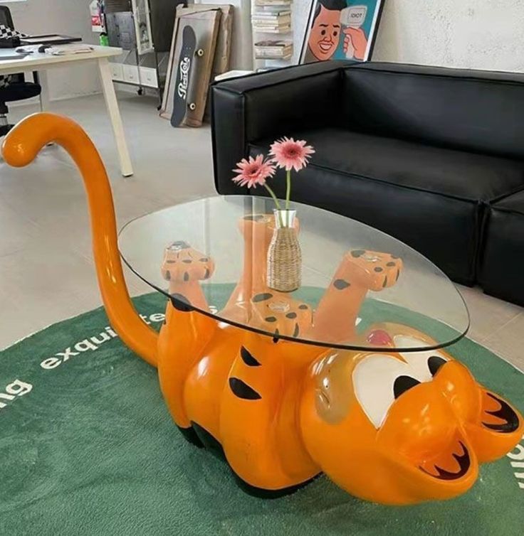 an orange cat coffee table sitting on top of a green rug