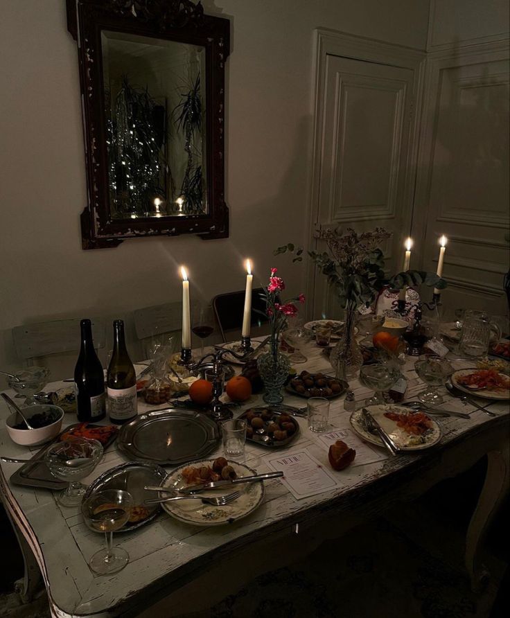 a dinner table is set with food and candles