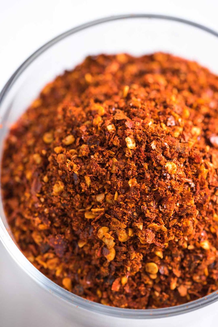 a glass bowl filled with spices on top of a table