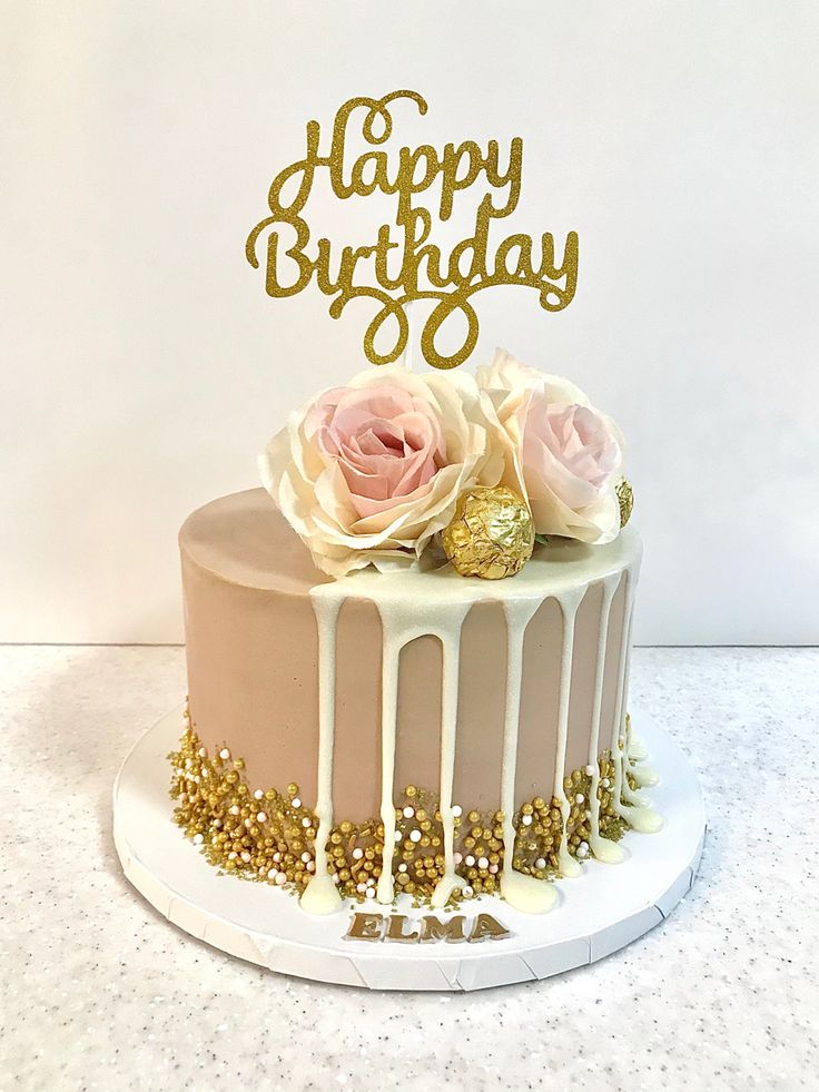 a birthday cake with white frosting and pink flowers on top that says happy birthday