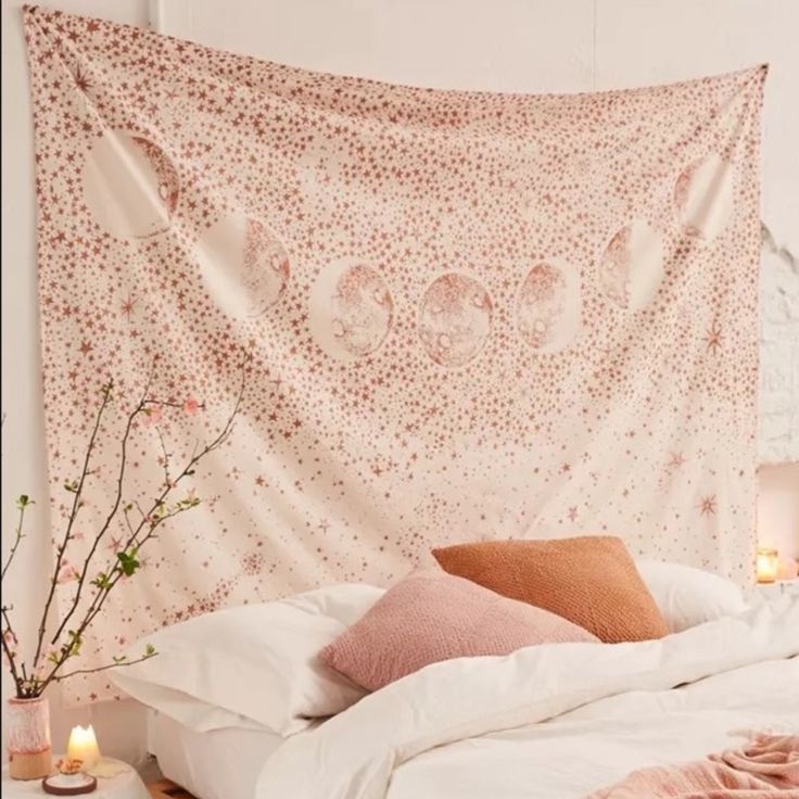 a white bed topped with pillows next to a wall covered in a large pink blanket