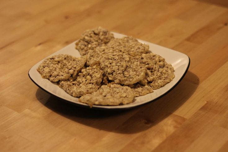 a white plate topped with oatmeal cookies on top of a wooden table