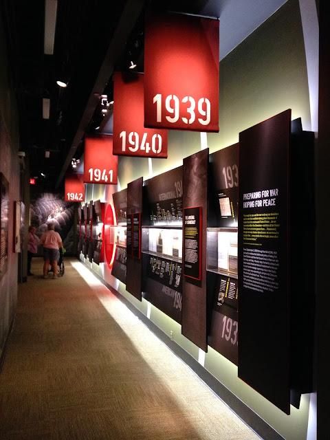 a long hallway with red and black signs hanging from the wall next to each other