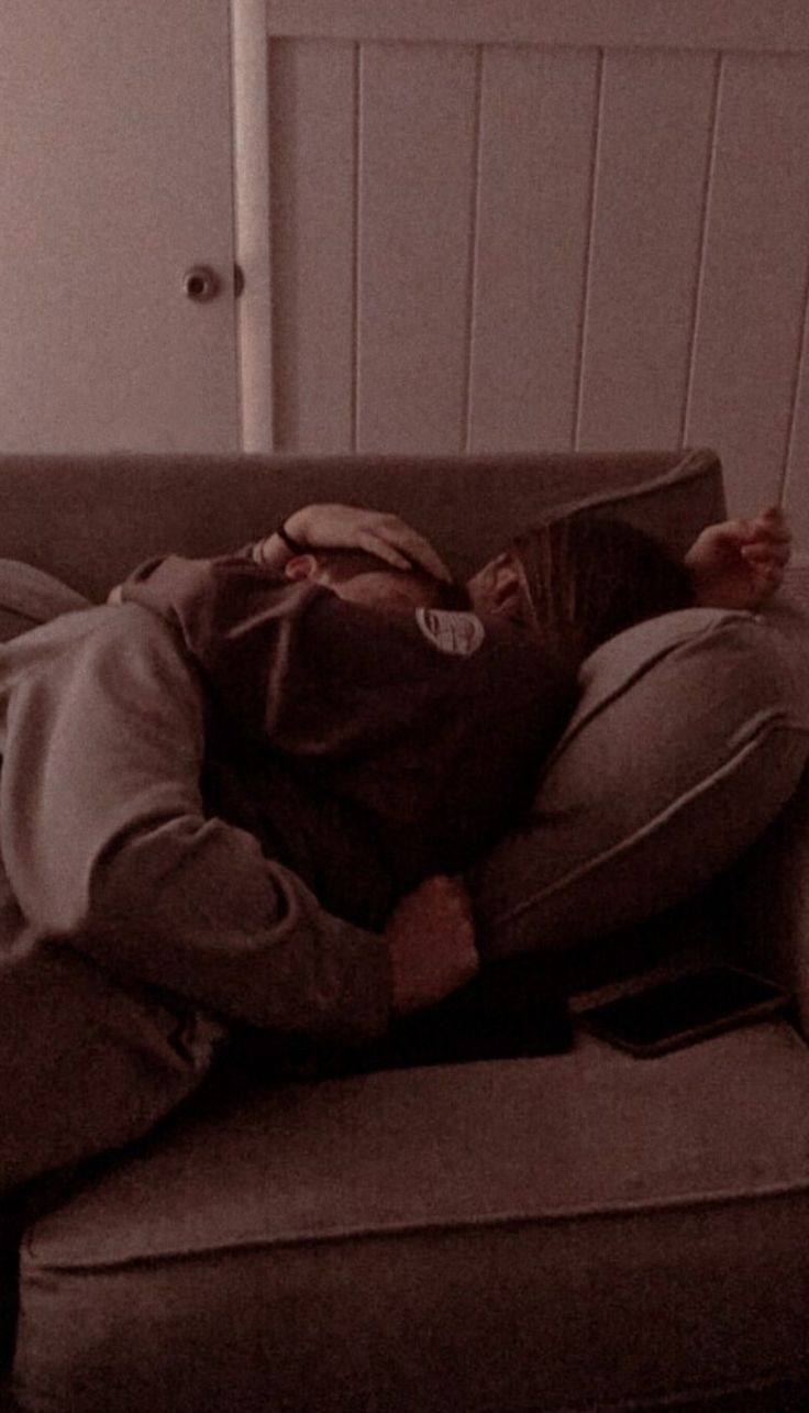 a man laying on top of a couch in a living room