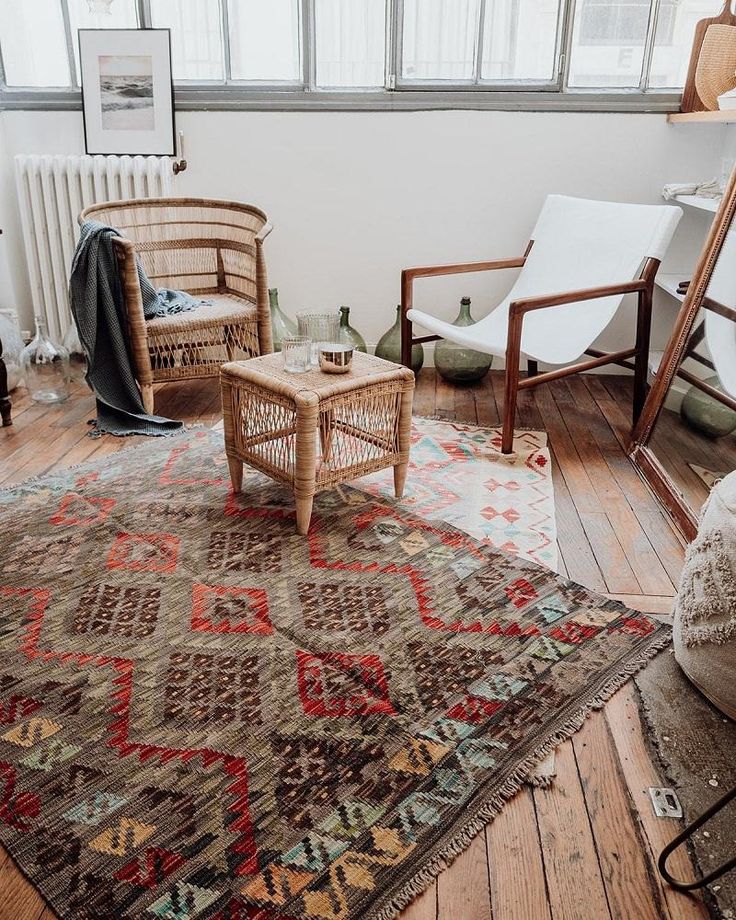 a living room filled with furniture and a large rug on top of a hard wood floor