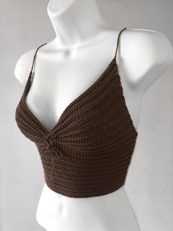 a mannequin wearing a brown crochet top with a knot on the front