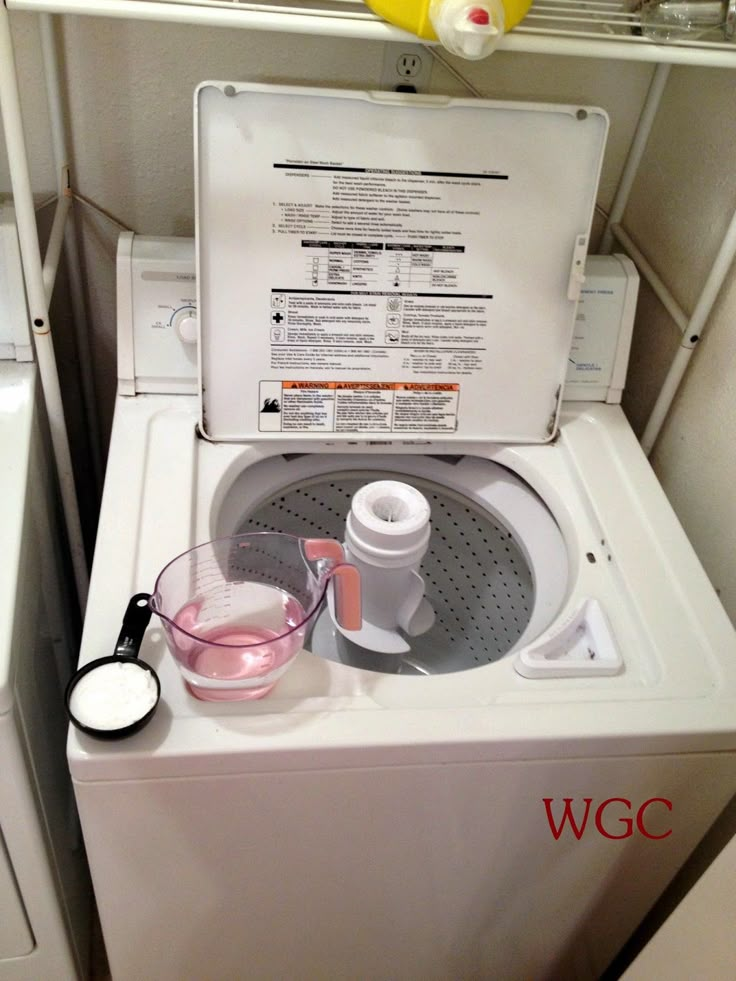 a washer with the lid open and some items on it