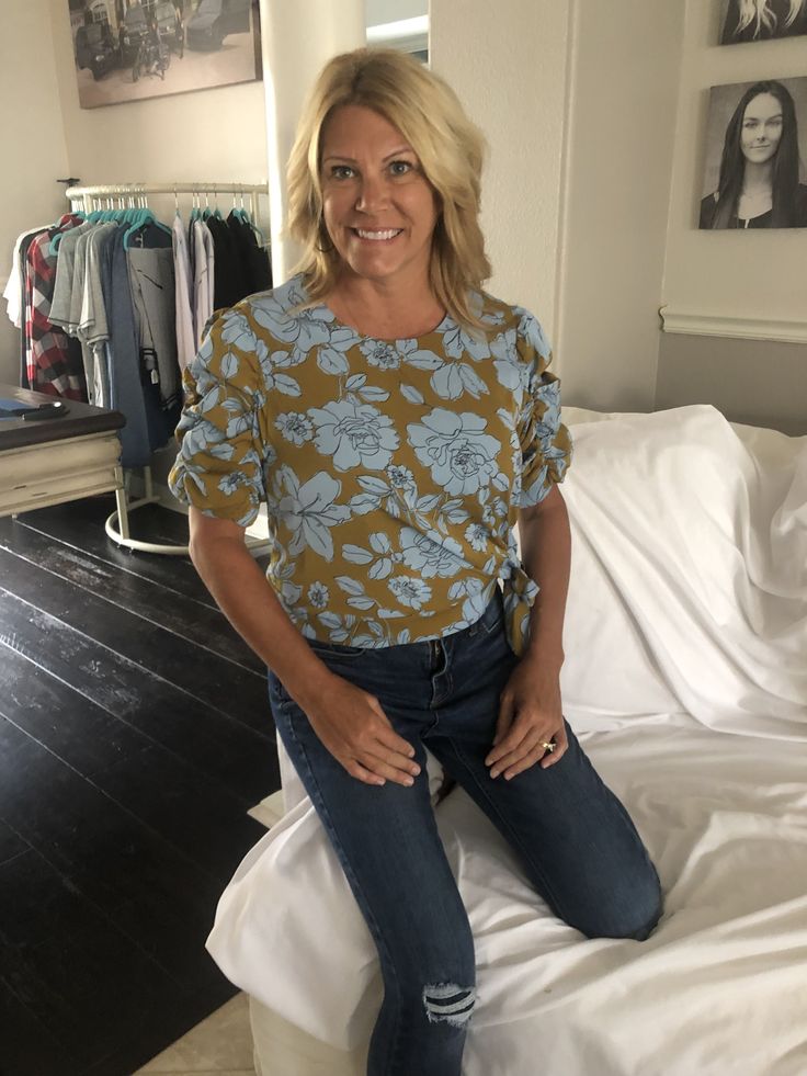 This adorable top is super versatile and can be worn during the summer or fall! Featuring a mustard yellow with baby blue flowers, a side tie, and adorable sleeve details this top is a statement piece that can be worn with jeans or slacks for the cutest outfit! 100% Polyester Casual Tops With Tie Sleeves For Brunch, Casual Tie Sleeve Blouse For Brunch, Casual Blouse With Tie Sleeves For Brunch, Blue Tops With Tie Sleeves For Spring, Fall Tops With Tie Sleeves For Day Out, Spring Fitted Tops With Tie Sleeves, Casual Blue Tops With Tie Sleeves, Casual Fitted Top With Tie Sleeves, Fitted Casual Tops With Tie Sleeves