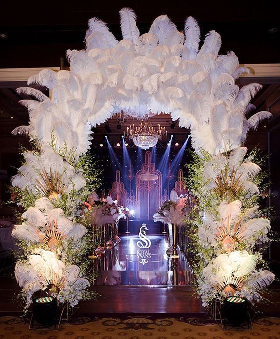 the stage is decorated with white flowers and feathers