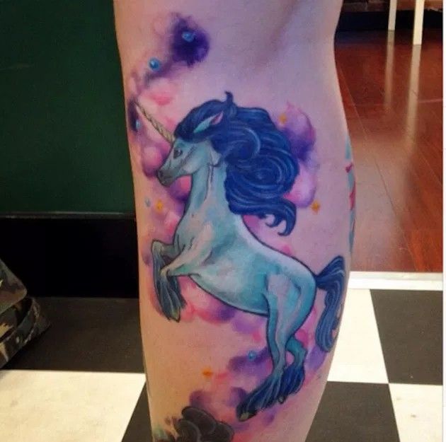 a woman's leg with a unicorn tattoo on it