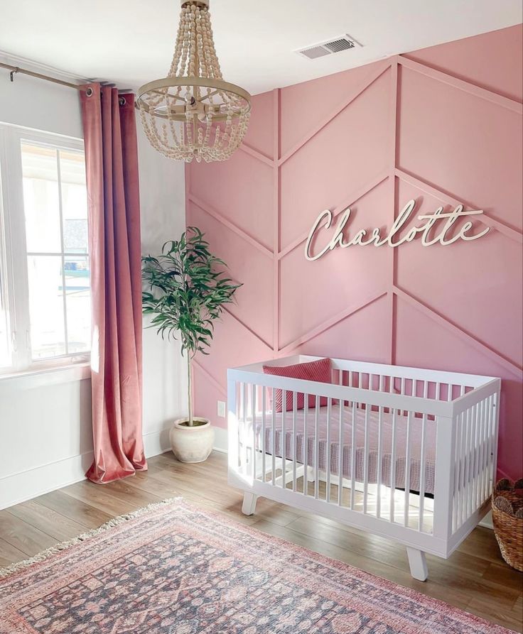 a baby's room with pink walls and white crib