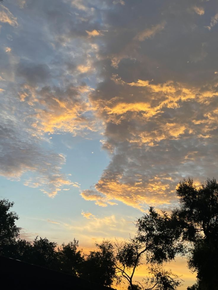 the sky is filled with clouds and trees