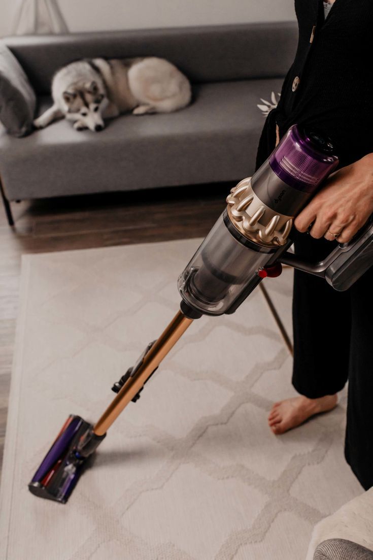 a woman is using a vacuum cleaner on the floor