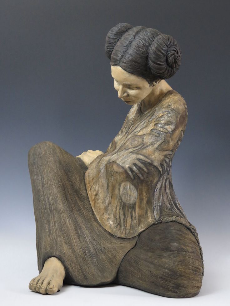 a statue of a woman sitting on the ground