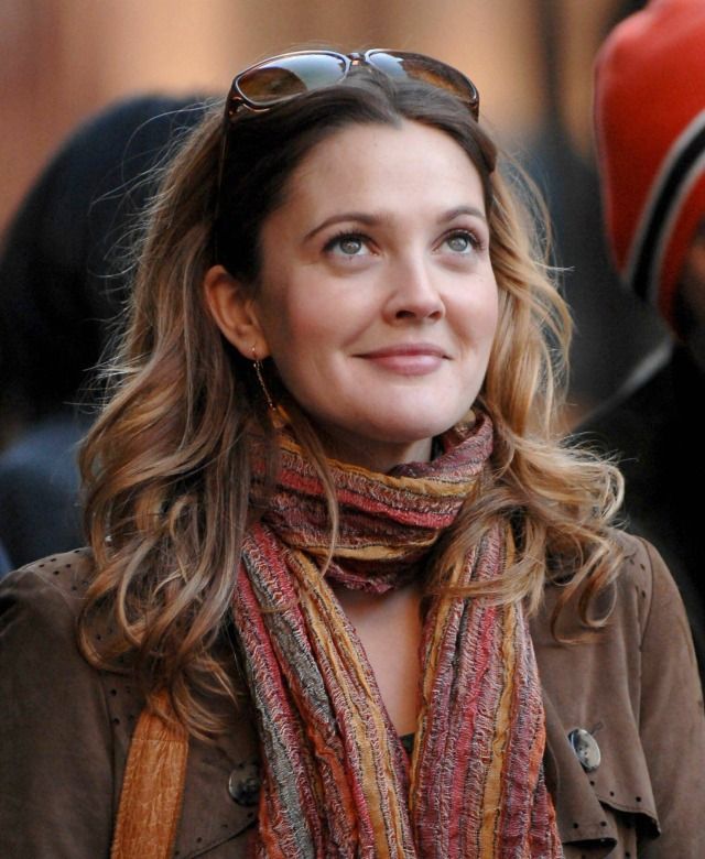 a woman wearing sunglasses and a scarf on the street