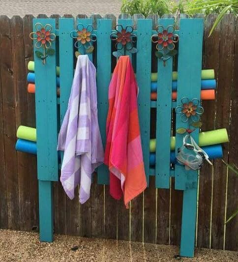 two towels are hanging on a wooden fence