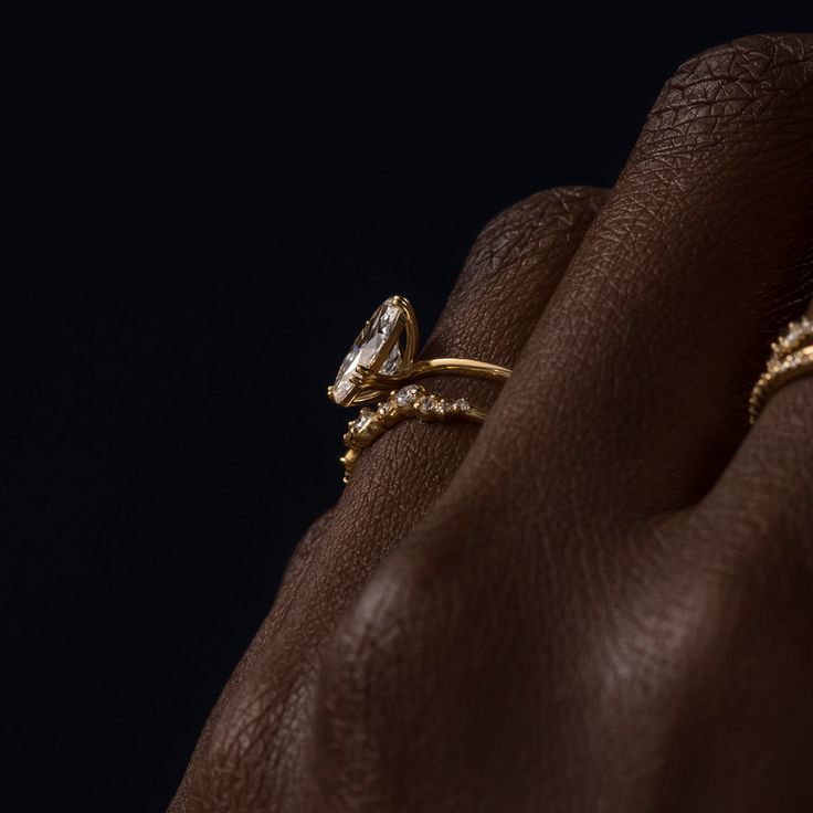 a woman's hand with a gold ring on her left wrist and diamond set in the middle