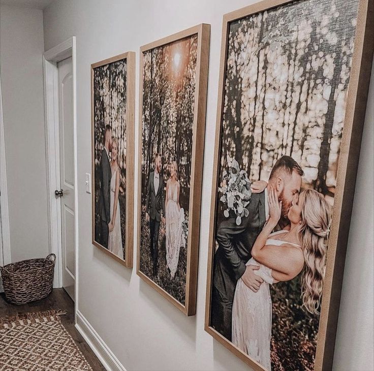 a couple kissing each other in front of three pictures on the wall next to a door