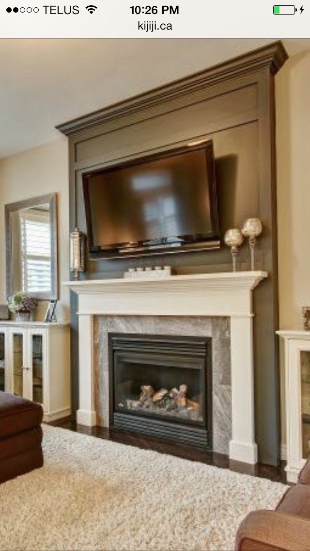 a living room with a fireplace and flat screen tv on the wall above it's mantle